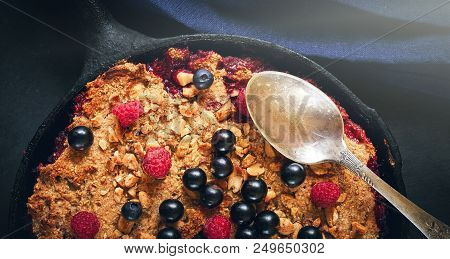 Summer Breakfast. Crumble With Blueberries In The Black Cast-iron Frying Pan On The Dark Stone Table