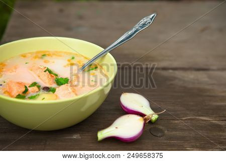 Fish Soup On An Old Wooden Table In Nature Among The Green Grass