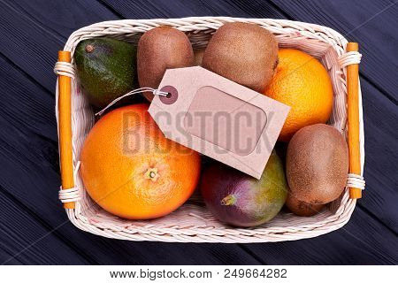 Assortment Of Fruits In Basket And Label. Assorted Tropical Fruits In Wicker Basket And Blank Cardbo