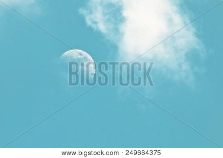 Pale Morning Moon In A Blue Sky With Clouds As A Background