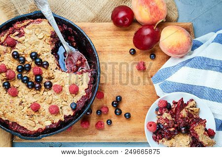 Food Background. Crumble With Blueberries In The Black Cast-iron Frying Pan On The Wooden Cutting Bo