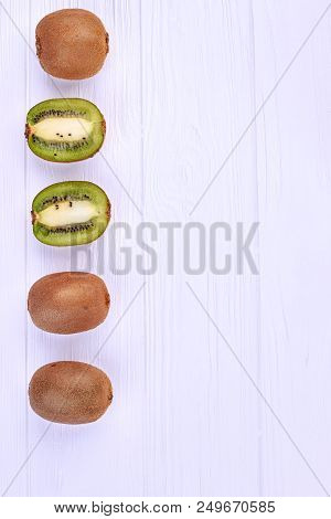 Ripe Kiwi Fruits And Copy Space. Row Of Whole And Sliced Kiwi With Text Space, Vertical Image.