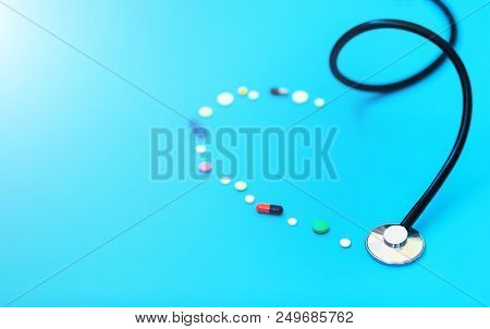 Medicine Stethoscope And Pills On Blue Background. Cardiology Heart Treatment.