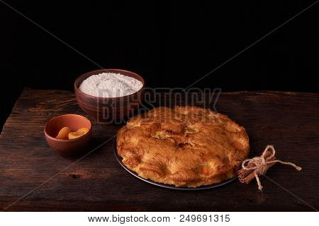 On A Dark Wooden Table, Fashionable Bakeries, A Bowl With Flour, Apricot Cake And Tools