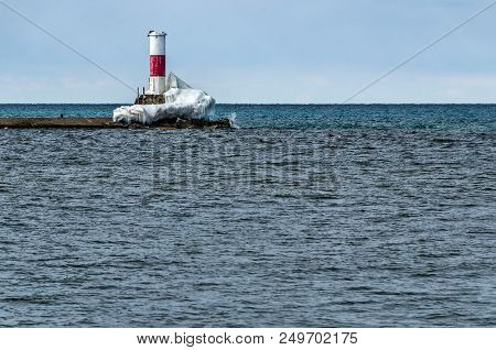 Red And White Beacon At The End Of An Icy Pier In Manistee, Michigan