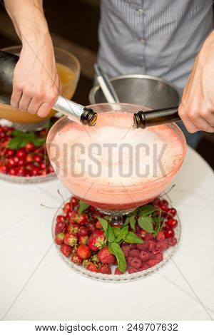 Beverage With Ice Cubes. Pouring Champagne. Mint And Fruit Are Out Of Focus