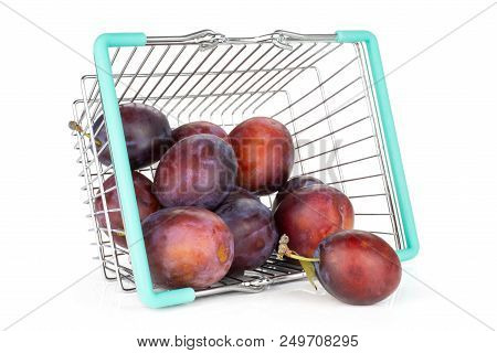 Lot Of Whole Fresh Violet-blue Plum Vibrant Moyer Variety Out Of A Shopping Basket Isolated On White