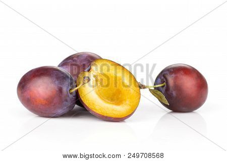 Group Of Three Whole One Half Of Fresh Violet-blue Plum Vibrant Moyer Variety Isolated On White