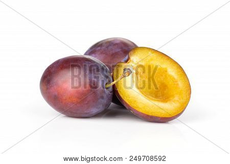 Group Of Two Whole One Half Of Fresh Violet-blue Plum Vibrant Moyer Variety Isolated On White