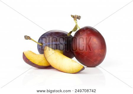 Group Of Two Whole Two Slices Of Fresh Violet-blue Plum Vibrant Moyer Variety Isolated On White