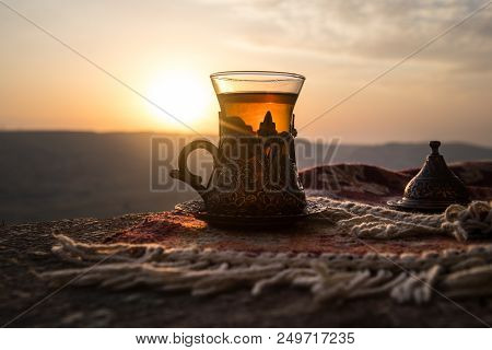 Arabian Tea In Glass On A Eastern Carpet. Eastern Tea Concept. Armudu Traditional Cup. Sunset Backgr