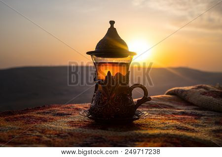 Arabian Tea In Glass On A Eastern Carpet. Eastern Tea Concept. Armudu Traditional Cup. Sunset Backgr