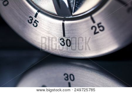 30 Minutes - A Macro Of An Analog Chrome Kitchen Timer With Dark Background And Reflection
