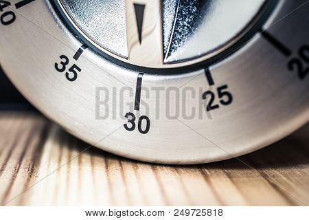 30 Minutes - A Macro Of An Analog Chrome Kitchen Timer On Wooden Table