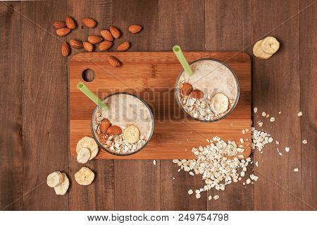 Two Portion Of Banana Smoothies With Oat Flakes, Almond And Banana Chips, Top View