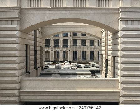 Old Fashion Brick Apartment And Loft Building With White Brick Masonry Pillars And Arches Over Green