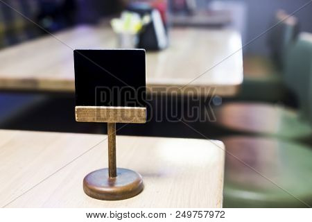 Chalky Wooden Plaque On A Table In A Cafe For Writing A Table Number. Moke Up