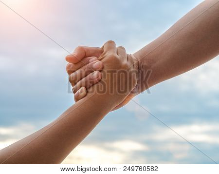 Closeup Helping Hands On The Sky Background. Rescue & Help Cencept