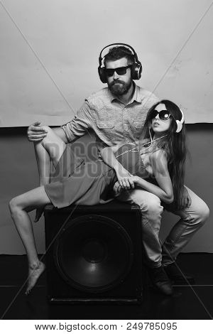 Music And Leisure Concept. Man With Beard Wears Headphones, Sunglasses. Couple In Love Lies On Louds