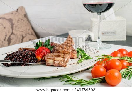 Appetizing Dish In A Restaurant: Juicy Mutton Ribs Of Medium Rare With Brown Rice, Strawberry And Sa