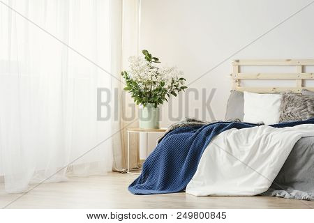 Navy Blue Blanket Thrown On Double Bed With Lights On Bedhead Standing In White Bedroom Interior Wit