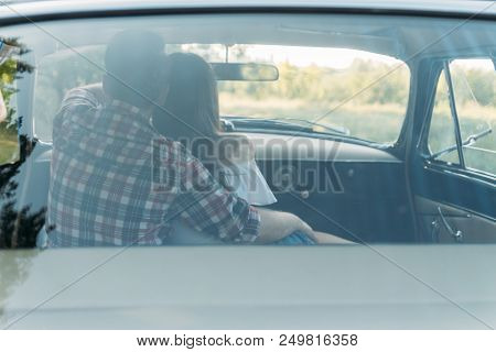 Couple, Man And Woman Are Sitting In The Car, The Guy Is Hugging The Girl. Traveling Together. Check