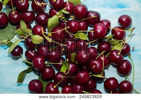 Fresh Sweet Cherries Bowl With Leaves In Water Drops On Wooden Blue Background