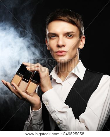 Beauty concept. Young male make up artist posing with foundation for make-up