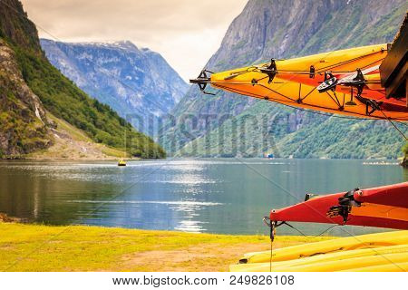 Active Lifestyle Sport Concept. Many Canoes Outdoor In Rental Center, Norwegian Fjord Landscape In T