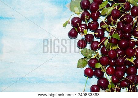 Red Fresh Ripe Cherries On Blue Background With Copy Space, Top View