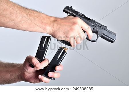 Man Reloading Pistol Gun After Shooting Isolated
