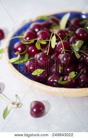 Close Up Of Pile Of Ripe Cherries In Blue Bowl.