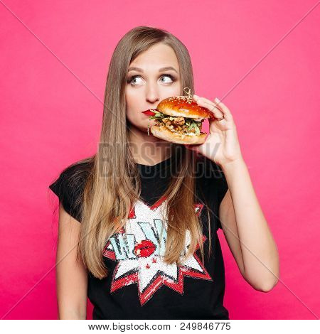Front View Of Sadly Young Girl Looking At Side And Thinking Eating Tasty Humburger Or No. Pretty Wom