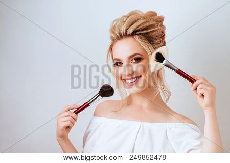 Fashion Glamour Portrait Of Happy Smiling Blonde Woman Long Wavy Hair Style Holding Brush Over Light