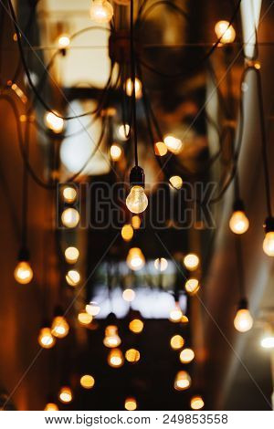 Burning Bulb Shines Weakly On The Background Blurred Yellow Lights