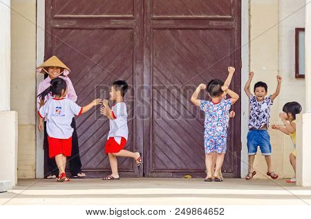 Cai Be, Vietnam - 6 April, 2018: Laughing Children Playing And Romping Around Under The Supervision 
