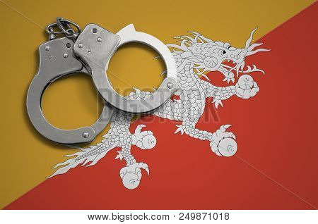 Bhutan Flag  And Police Handcuffs. The Concept Of Crime And Offenses In The Country.