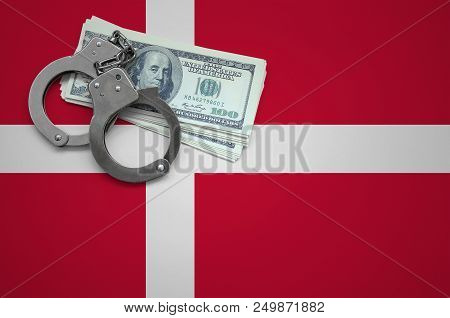 Denmark Flag  With Handcuffs And A Bundle Of Dollars. The Concept Of Breaking The Law And Thieves Cr