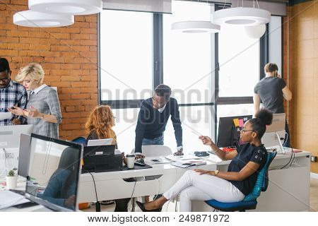 Two African People Are Giving Reccomendations To Motivated Girl In Glasses With Red Hair