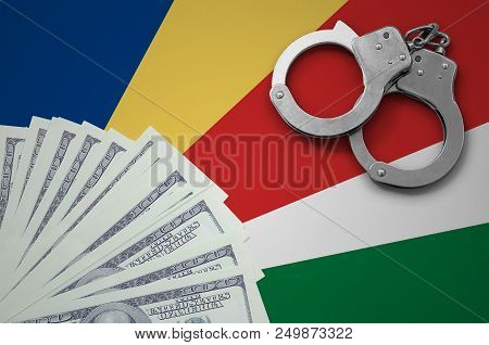 Seychelles Flag  With Handcuffs And A Bundle Of Dollars. The Concept Of Illegal Banking Operations I