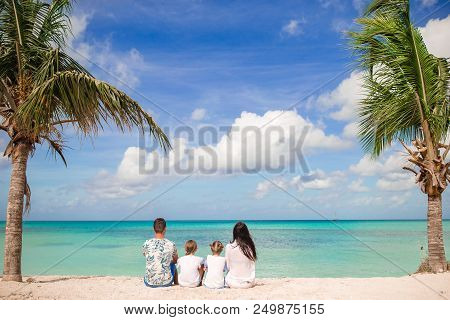 Caucasian Family Sit On The Sandy Beach