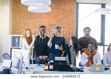 Young Multi Ethnic People Are Laughing At Work While Their African Partner Feels Bad. Afro Man Disli