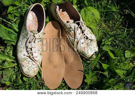 Leather Orthopedic Insoles With Running Shoes On The Grass. Healthy Relax On Nature. Outdoors.