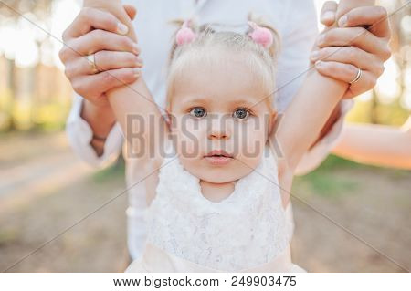 Cild Emotion. Dad Raises For The Child's Hands In Front Of Him. Family In Summer Sunny Park. Stylish