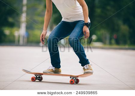 One Woman Skateboarder Sakteboarding On Parking Lot