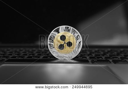 Silver Gold Ripple Coin On A Laptop Keyboard Closeup. Blockchain Mining. Digital Money And Virtual C