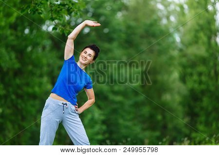 Elderly Female Doing Fitness Exercises Outdoor. Heathy Life Style Concept. Copyspace.