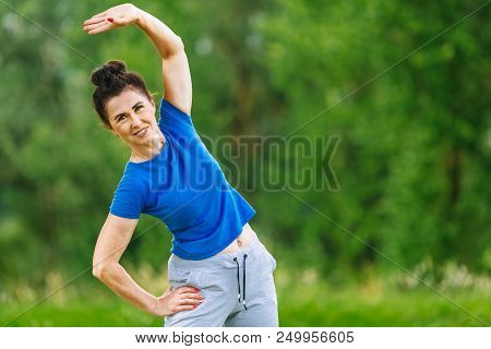 Elderly Female Doing Fitness Exercises Outdoor. Heathy Life Style Concept. Copyspace.