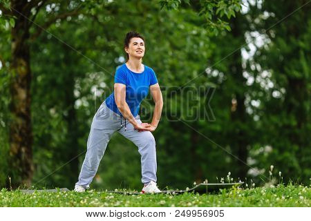 Elderly Female Doing Fitness Exercises Outdoor. Heathy Life Style Concept. Copyspace.