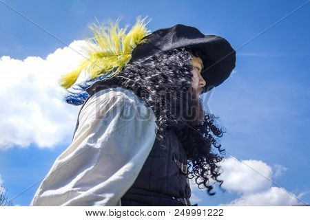Musketeer With A Wide Hat And Long Curly Hair Against Blue Sky, Denmark, May 21, 2017